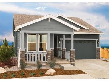 Charming single-Gathering home boasting a welcoming front porch with stylish stone accents and a two-car garage at 21085 E 61St Dr, Aurora, CO 80019