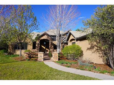 Charming stucco home with stone accents, mature trees, and a welcoming front walkway at 5722 S Benton Way, Littleton, CO 80123