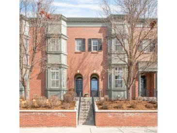 Charming red brick townhome featuring arched doorways and bay windows, creating a welcoming facade at 2958 N Xenia St, Denver, CO 80238