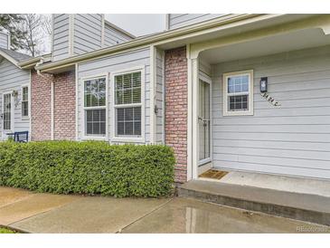 Charming front entrance featuring brick accents, a welcoming door mat, and well-maintained landscaping at 5404 W Canyon Trl # C, Littleton, CO 80128