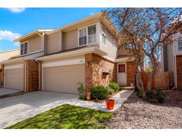 Inviting two-story townhouse featuring a well-maintained lawn, brick accents, and an attached one-car garage at 1578 S Syracuse St, Denver, CO 80231