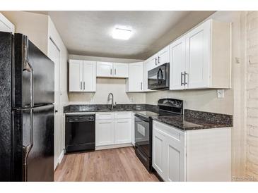 Updated kitchen features white cabinets, granite countertops, and modern appliances at 875 S Quebec St # 24, Denver, CO 80247