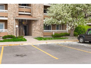Charming condo building featuring stone accents, beige siding and vibrant flowering tree at 1074 S Dearborn St # 103, Aurora, CO 80012