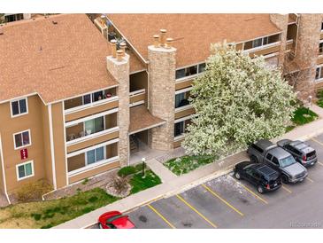 Aerial view showcases the condo's facade, stone details, balconies, mature landscaping, and convenient parking at 1074 S Dearborn St # 103, Aurora, CO 80012