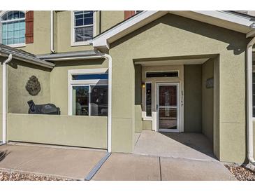 Home's inviting front entrance features a stylish door, visible house number, and covered porch at 6916 Crestop Pl # F, Parker, CO 80138