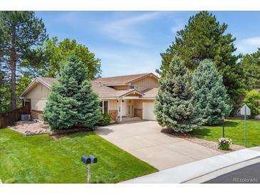 Charming home with a well-manicured lawn and mature landscaping at 6407 S Heritage W Pl, Centennial, CO 80111