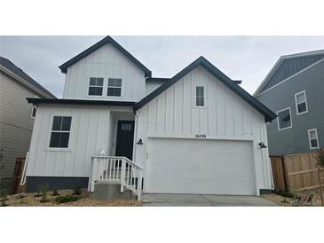 Charming two-story home featuring a bright white exterior and a convenient two-car garage at 16498 W 92Nd Pl, Arvada, CO 80007