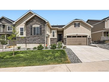 Charming home featuring stone accents, a well-manicured lawn, and a two-car garage with a warm and inviting facade at 4536 Shady Path Ln, Castle Rock, CO 80104