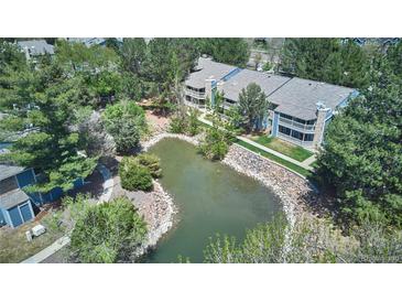 Aerial view of a condo community with a small pond and lush landscaping at 8600 E Alameda Ave # 17-203, Denver, CO 80247