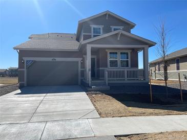 Charming home featuring a covered front porch, attached garage and well-manicured lawn at 16612 E 109Th Ave, Commerce City, CO 80022