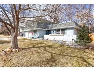 Charming two-story home with light blue exterior, gray roof, and mature trees at 3241 S Krameria St, Denver, CO 80222