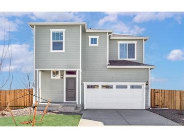 Charming two-story home featuring a front-facing garage, and a well-maintained lawn at 9474 Yampa St, Commerce City, CO 80022