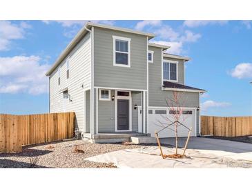 Charming two-story home featuring a covered entry, attached two-car garage and low maintenance yard at 9474 Yampa St, Commerce City, CO 80022