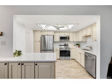 Bright kitchen boasts stainless steel appliances, a ceiling fan, and neutral color palette at 14300 E Marina Dr # 306, Aurora, CO 80014