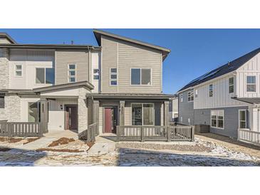 Modern two-story townhome with gray siding, private patio, and walkway at 14586 W 91St Ave # A, Arvada, CO 80005