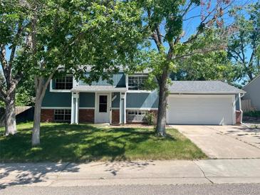 Ranch style home with blue siding, attached garage, and well-maintained lawn at 4678 S Lewiston Way, Aurora, CO 80015