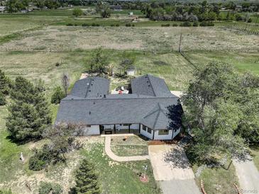 Aerial view of home with mature trees, gray roof, and large surrounding fenced in property at 1428 S County Road 23E, Berthoud, CO 80513