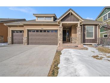 Charming home featuring a two-car garage, stone accents, and a welcoming front porch at 160 Pipit Lake Way, Erie, CO 80516