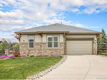Charming single Gathering home with beautiful stone accents, a well-manicured lawn and a two car garage at 19379 W 57Th Pl, Golden, CO 80403
