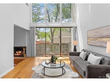 Bright living room with large windows, fireplace, and modern decor at 1050 S Monaco Pkwy # 68, Denver, CO 80224