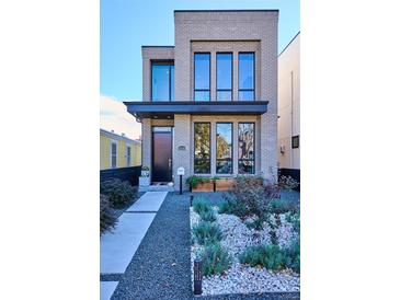 Modern two-story home with landscaped front yard and gray brick exterior at 3048 Stout St, Denver, CO 80205