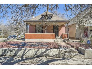 Charming home with a brick facade, covered porch, and landscaped front yard, creating curb appeal at 3456 Quivas St, Denver, CO 80211