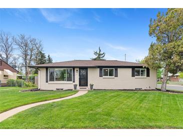 Charming home featuring a manicured lawn, updated windows and a paved walkway leading to the front door at 9790 E 5Th Ave, Aurora, CO 80010