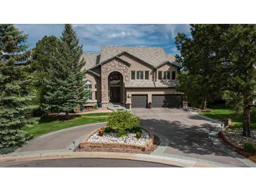 Stately stone and stucco home with circular driveway and mature landscaping at 171 October Pl, Castle Rock, CO 80104