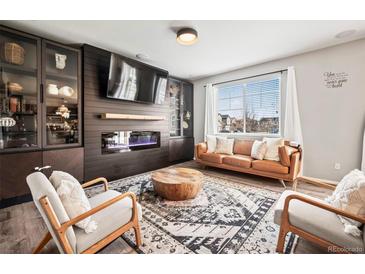 Modern living room with a fireplace, large TV, display cabinets and lots of natural light at 2688 Loon Cir, Castle Rock, CO 80104