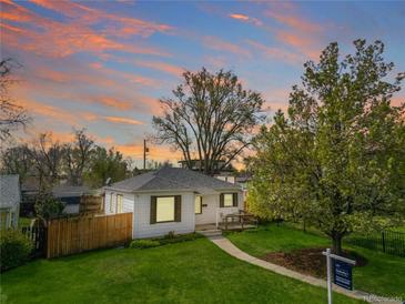 Charming single-story home with a well-maintained lawn and mature trees against a picturesque sunset backdrop at 1615 S Elizabeth St, Denver, CO 80210