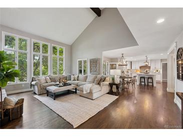 Spacious living room with large windows, hardwood floors, and an open floor plan to the kitchen at 11453 E Orchard Pl, Englewood, CO 80111