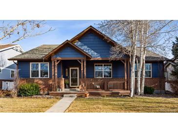 Charming home with a brick foundation, blue siding, and a covered front porch for relaxing at 2412 Windmill Dr, Longmont, CO 80504