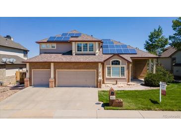 Charming two-story home with a brick facade, well-manicured lawn, and solar panels for energy efficiency at 58 Rogers Ct, Golden, CO 80401