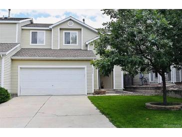 Charming two-story home features a two-car garage, manicured lawn, and classic architectural details at 5546 S Quemoy Cir, Aurora, CO 80015