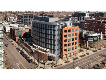 Modern, multi-story building with a curved facade, showcasing contemporary architecture in an urban setting near shops and businesses at 100 Detroit St # 103, Denver, CO 80206