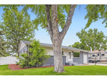 Charming home featuring a gray brick facade and a well-manicured lawn at 5150 W Colgate Pl, Denver, CO 80236