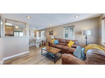 Open-concept living room with modern decor, hardwood floors, and a comfortable leather sofa set at 3282 W 66Th Ave, Denver, CO 80221