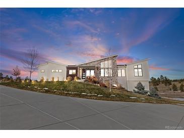 Modern home exterior with stone accents and expansive windows at 10205 Inspiration Dr, Parker, CO 80138