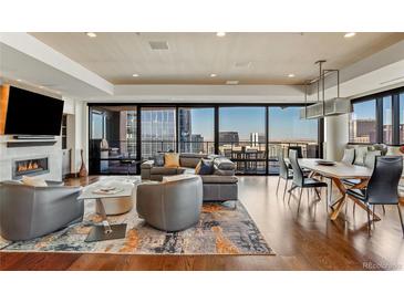 Modern living room featuring a fireplace, city views, and an open floor plan with hardwood floors at 1133 14Th St # 3320, Denver, CO 80202