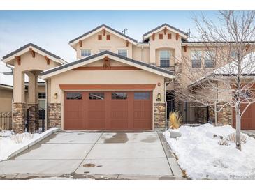 Charming two-story home featuring a spacious brown garage door, stucco siding, and stone accents at 2966 Casalon Cir, Superior, CO 80027