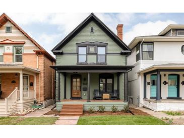 Charming two-story home with a covered front porch, green siding, and a well-maintained lawn at 940 N Ogden, Denver, CO 80218