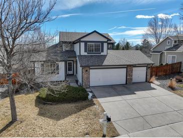 Charming two-story home featuring a three car garage and well maintained front yard and stone accents at 7036 Orion Ln, Arvada, CO 80007