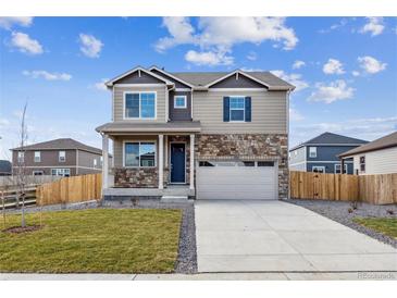 Charming two-story home boasts stone accents, a spacious two-car garage, and landscaped front yard at 27554 E Byers Ave, Aurora, CO 80018