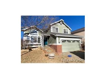 Two-story house with green siding, attached garage, and landscaping at 10703 Jordan Ct, Parker, CO 80134