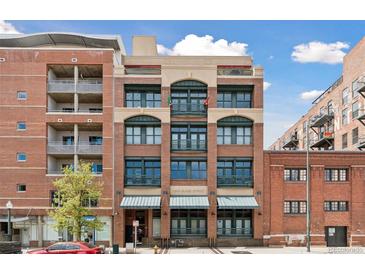 A brick multi-story building with green-trimmed windows, and small balconies outside some windows at 2245 Blake St # C, Denver, CO 80205