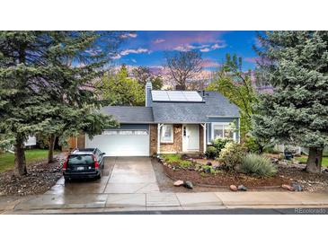 Charming single Gathering home with blue trim, brick accents, solar panels and a two car garage at 323 S Hoover Ave, Louisville, CO 80027