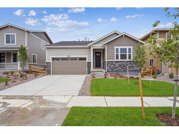 Charming single-Gathering home featuring stone accents, a two-car garage, and a well-manicured lawn at 24747 E 40Th Ave, Aurora, CO 80019