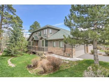 Beautiful home with a stone foundation, attached garage and nicely landscaped yard at 31139 Tahoe Ct, Evergreen, CO 80439