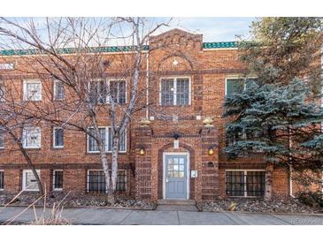 Charming brick building with an arched entryway and stone accents and a light gray front door at 1024 E 14Th Ave # 9, Denver, CO 80218