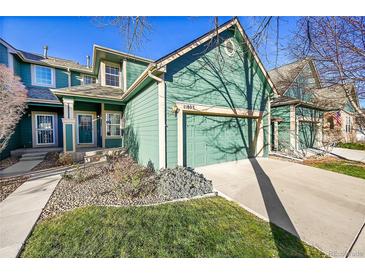 Inviting exterior of home featuring a two-car garage, manicured lawn and an inviting covered porch at 11803 W Stanford Dr, Morrison, CO 80465